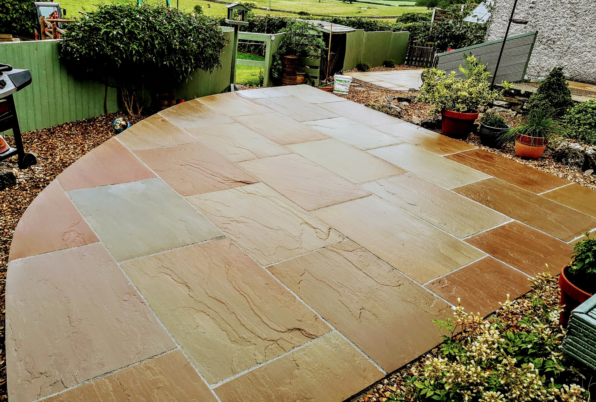 Curved sandstone patio edged with planting