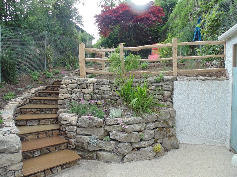 Curved drystone wall terrace with timber-edged steps and a split-rail fence