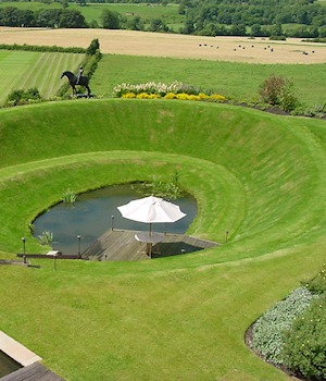 A spiral grass amphitheatre around a pond
