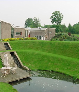 Grass terraces stepping down to a pond and deck
