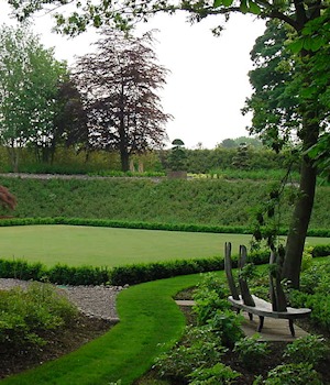 Lawns, hedges and a bench beside a sculpture