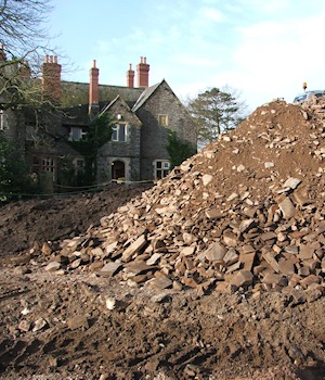 A heap of stone spoil in front of the house